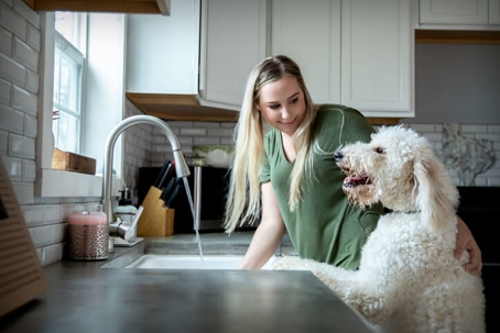 happy woman and dog at sink